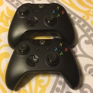 Two black wireless xbox one controllers